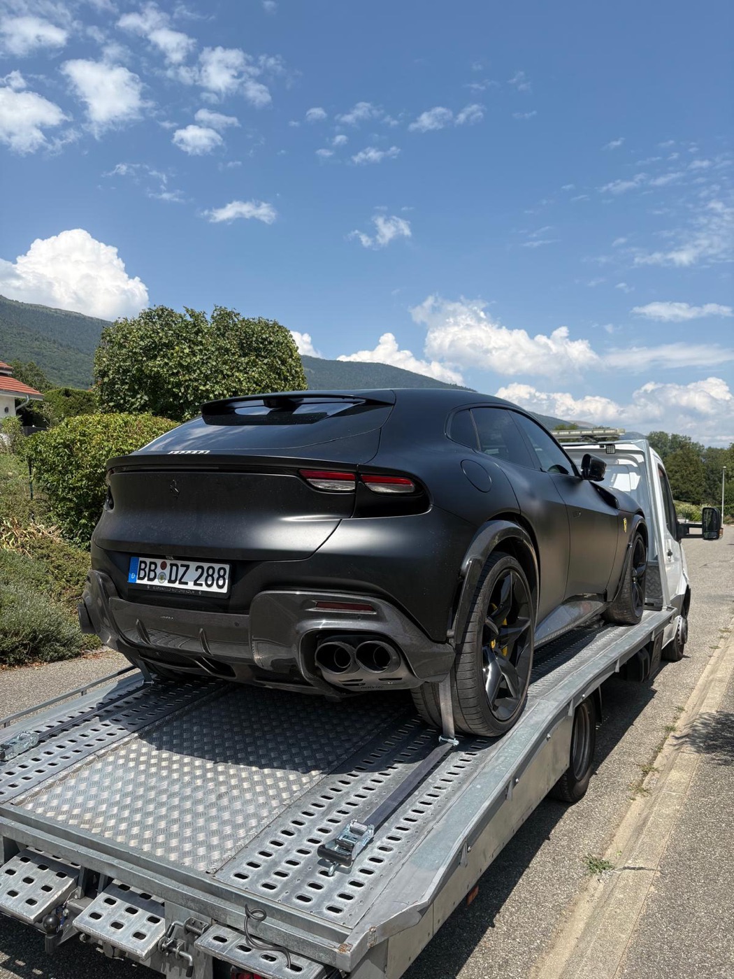 Ferrari Purosangue noire mate devant les montagnes